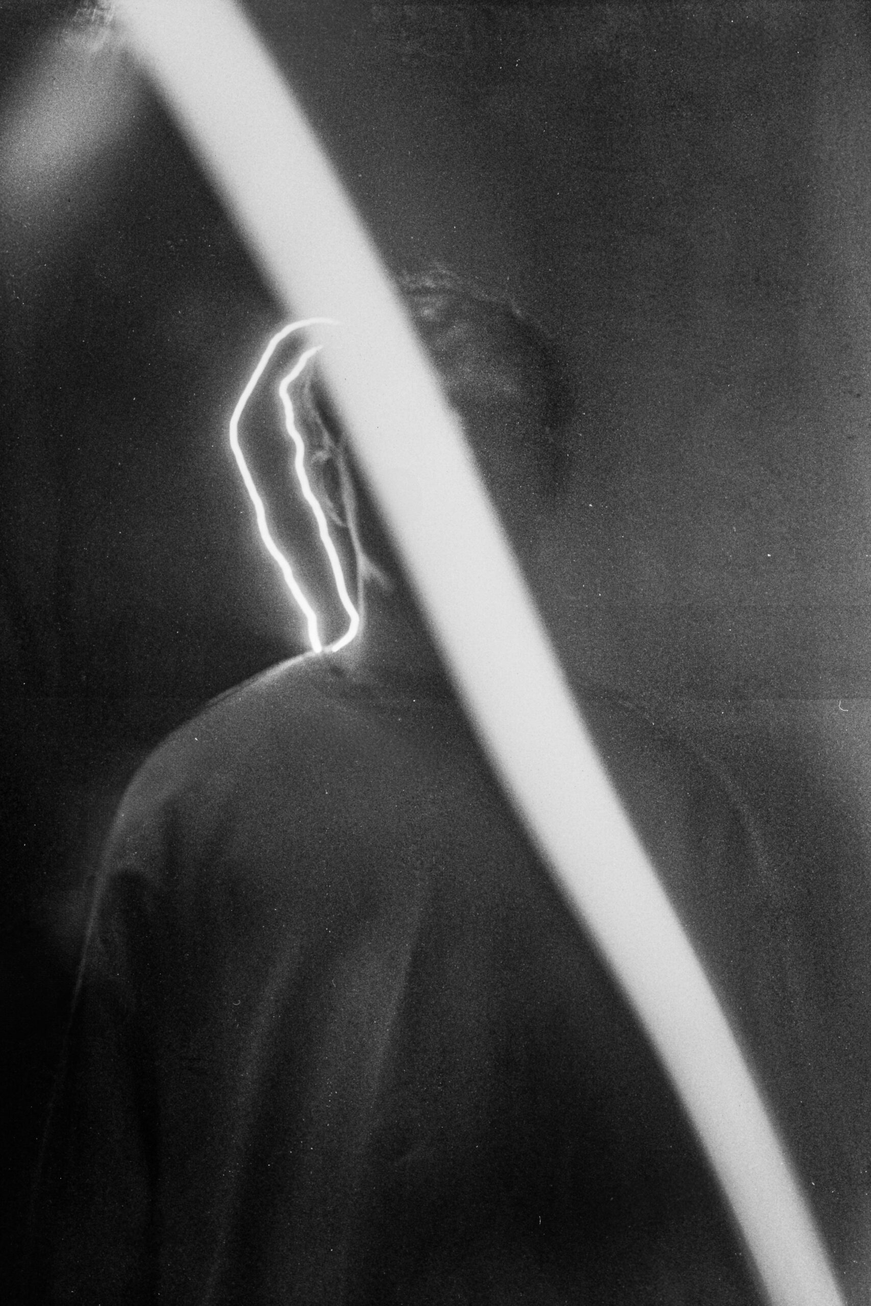 Black and white artistic photo of a Cerny tesak with a bright light streak in a dark background.